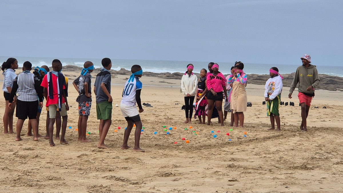 Blindfolded team game on the beach