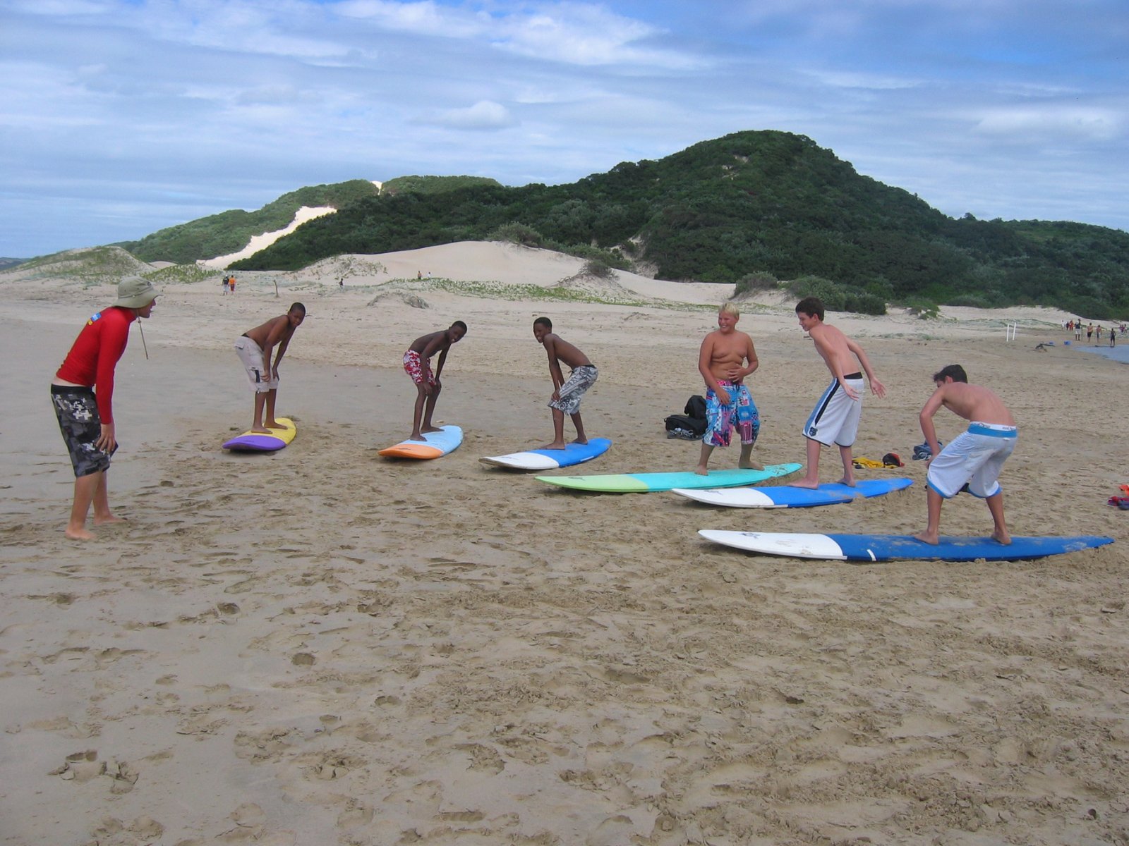 Surf lesson pop-up practice on the sand in front of the Cefani dunes