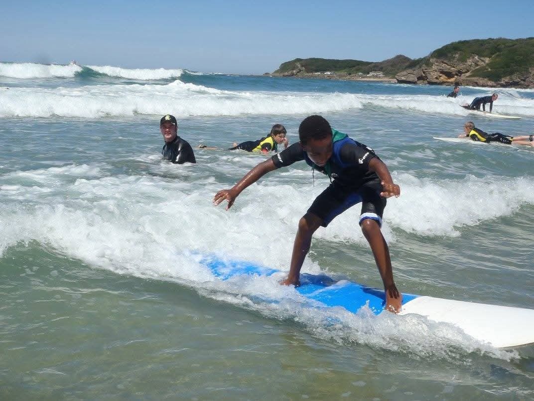 Young surfer standing up on a wave